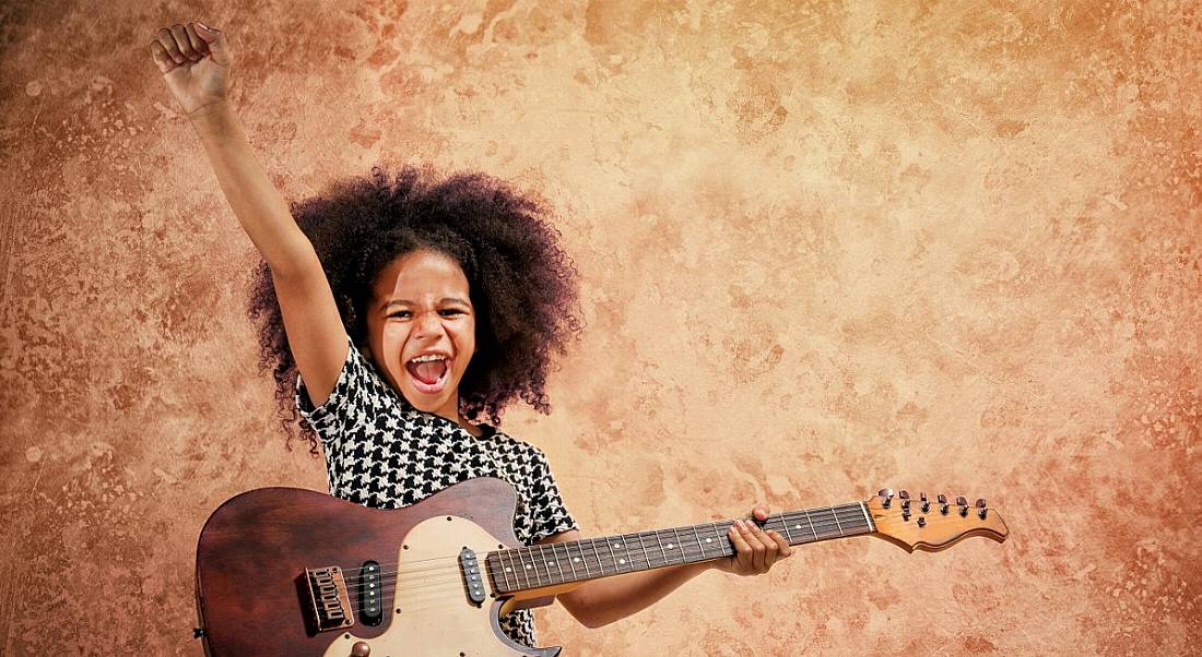 Young girl playing a guitar.