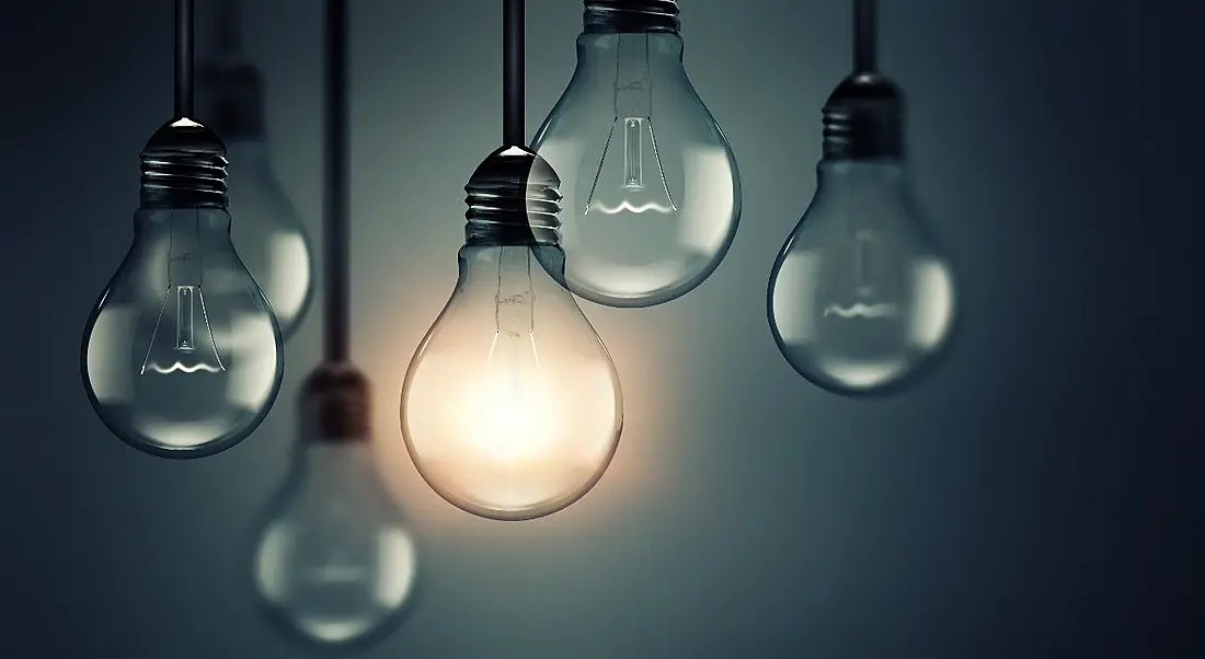 Six lightbulbs hanging against a grey background. One is lit up representing the one that’s prepared for the future of work.