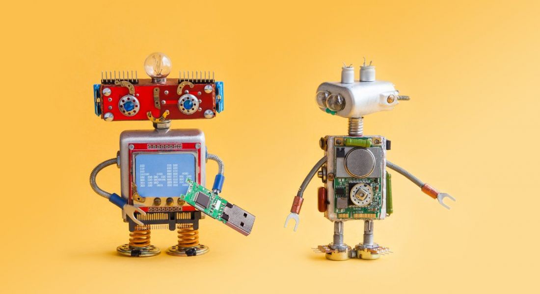 Two toy robots against a bright yellow background.