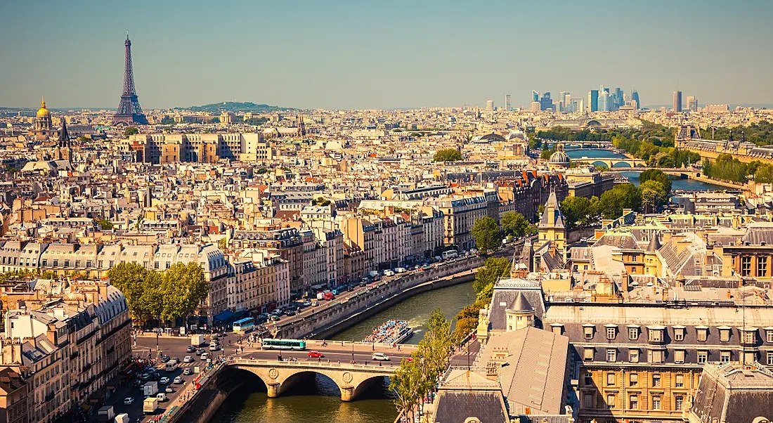 A scenic view of Paris. The River Seine runs from the foreground to the background. The Eiffel Tower is in the top left.