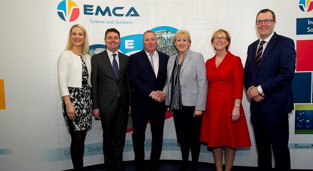 Three men and three women stand side by side in front of an EMCA sign.