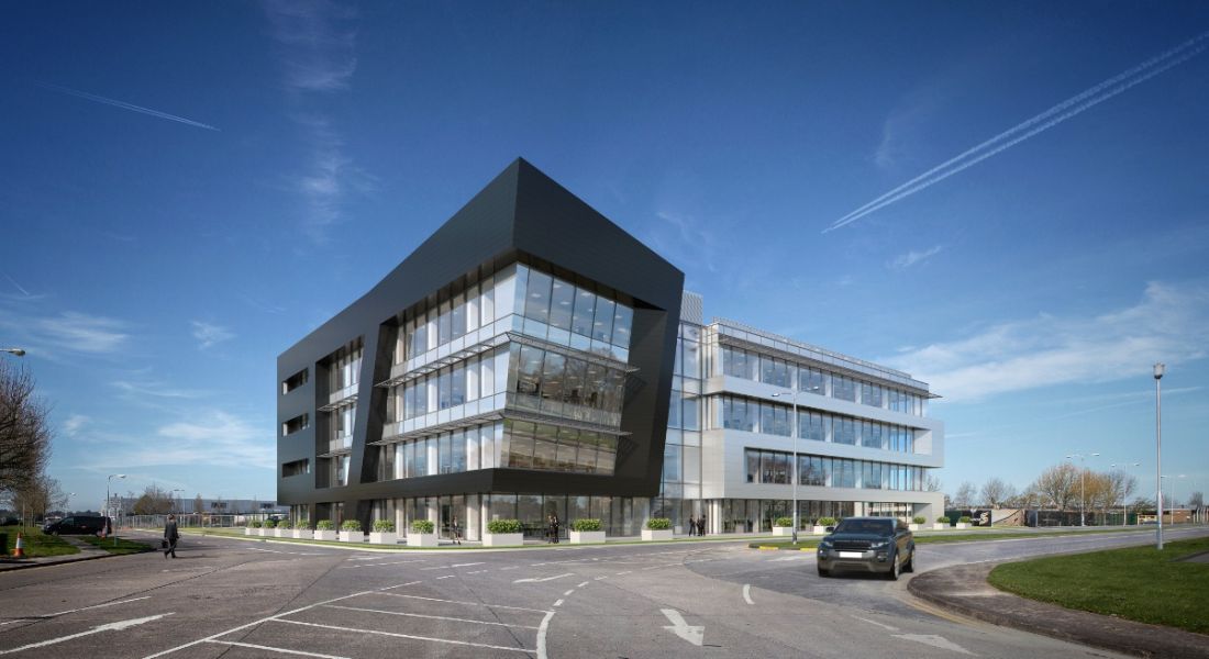 A large, modern, state-of-the art Jaguar Land Rover office exterior with lots of windows and a blue sky in the background.
