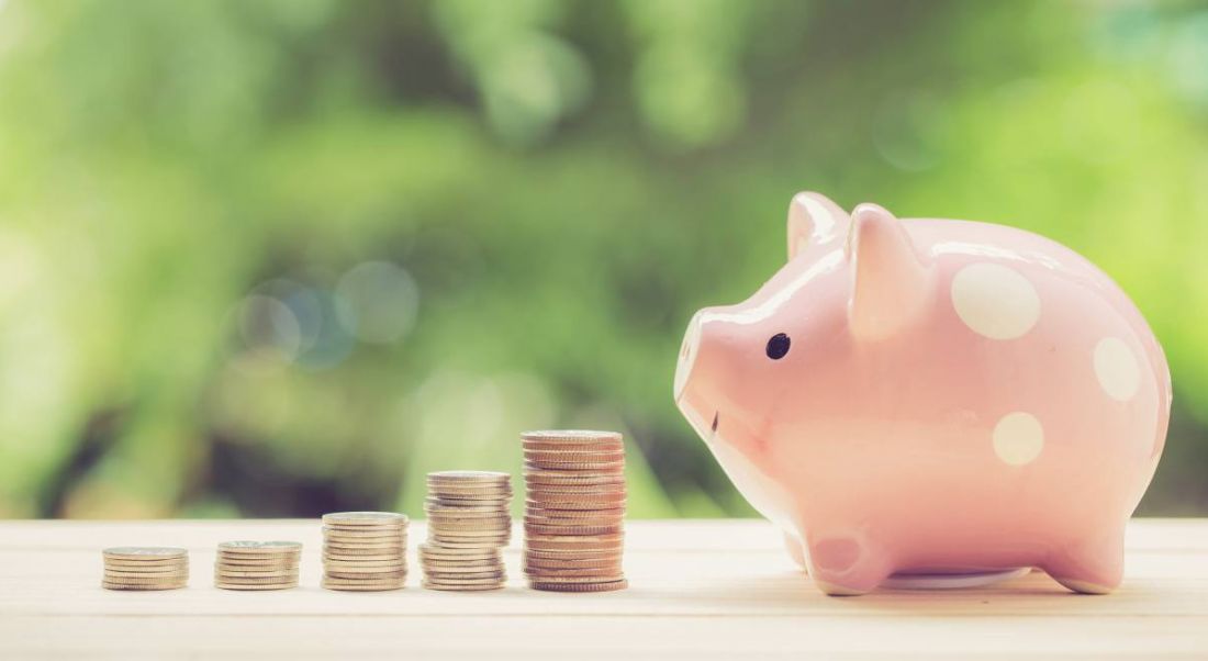 A stack of coins leading to other stacks that gradually get bigger, leading to a pink piggy bank representing pay increases.