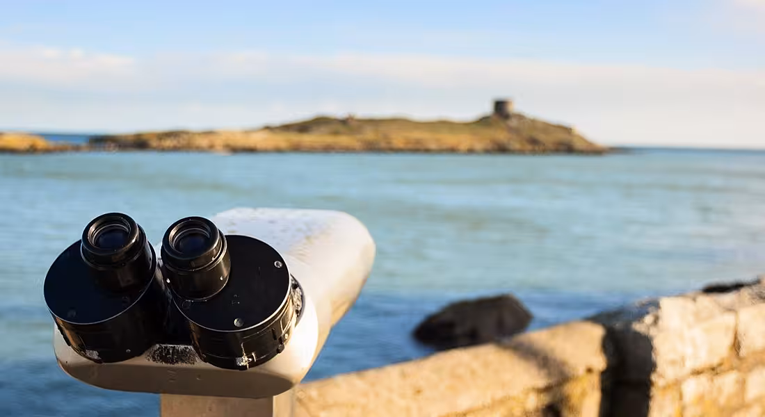 Coin-operated telescope overlooking an island of Ireland's coast.