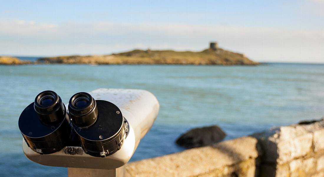 Coin-operated telescope overlooking an island of Ireland's coast.