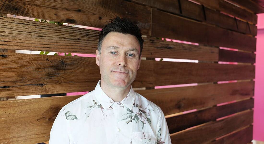 A headshot of a man with dark hair and short-sleeved white floral shirt. He works in UX design in Accenture.