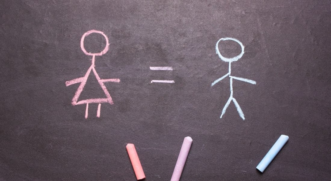 A chalkboard with a pink chalk stick woman with an equals sign beside a blue chalk stick man, showing gender balance.