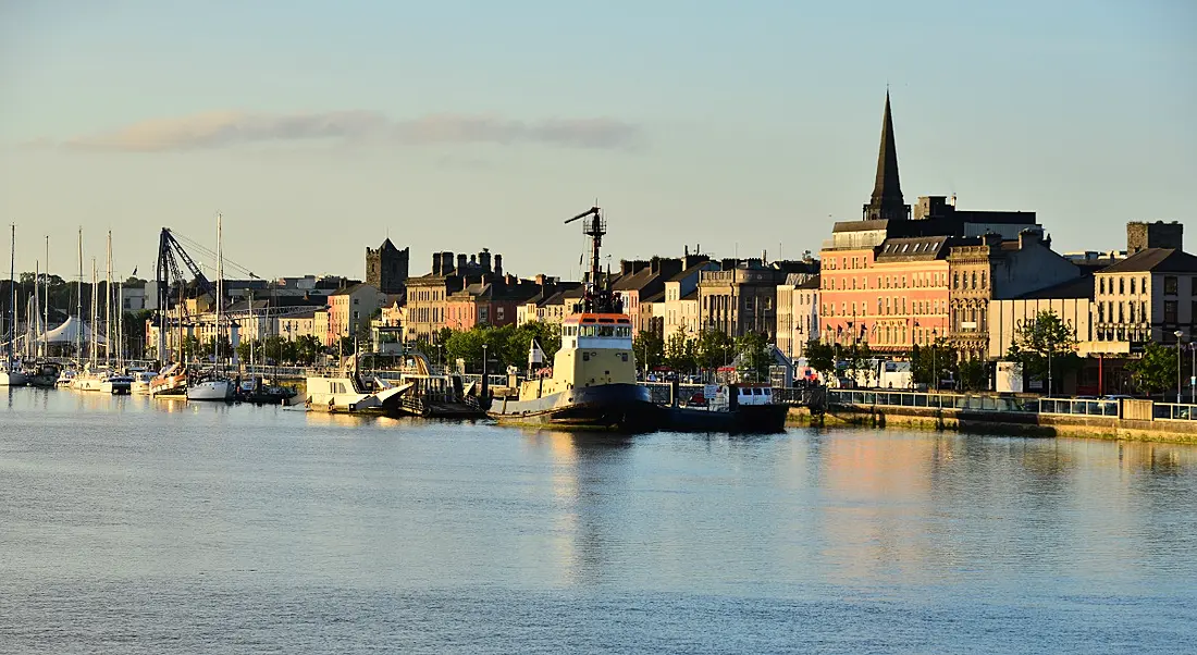 View of Waterford town against the skyline, beside a body of water.