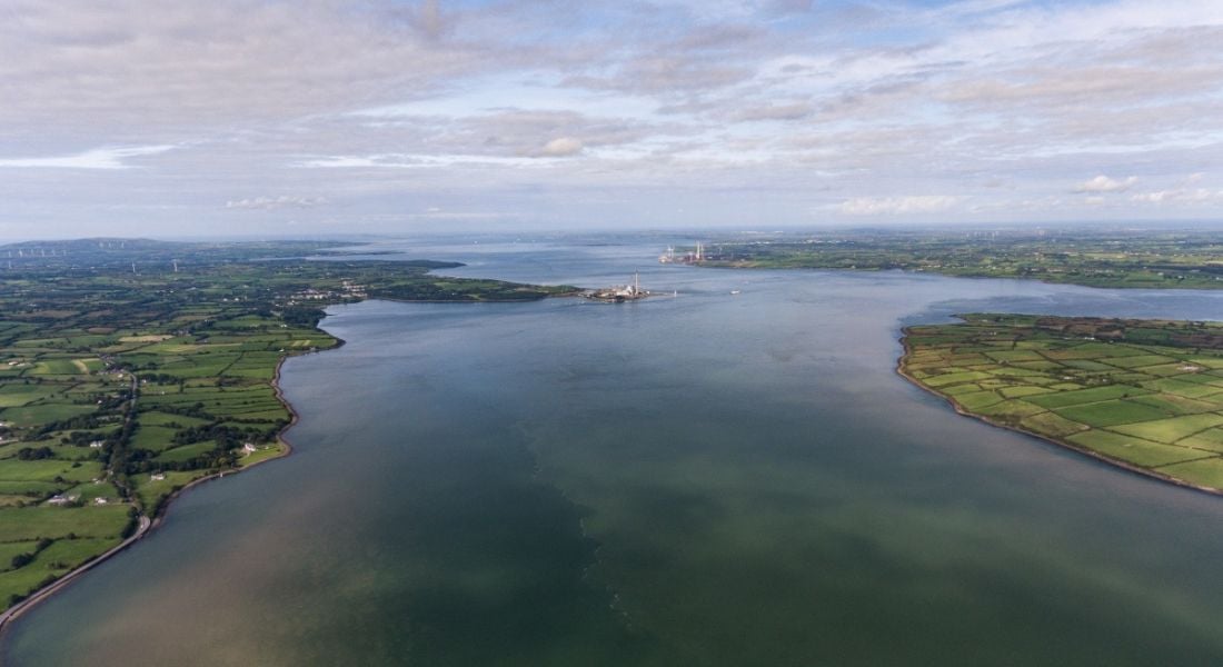 Aerial view of the eblow of river Shannon flanked by grassy banks.