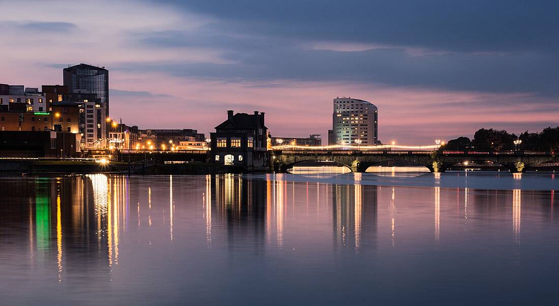 View of city skyline next to body of water in Limerick, Ireland.