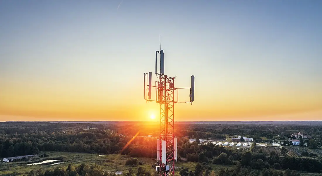 View of telecoms tower against cloudless sky at sunrise.