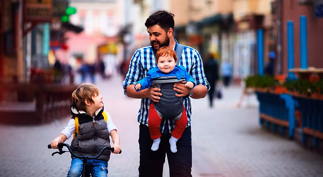 A happy father and two sons walking together outside.