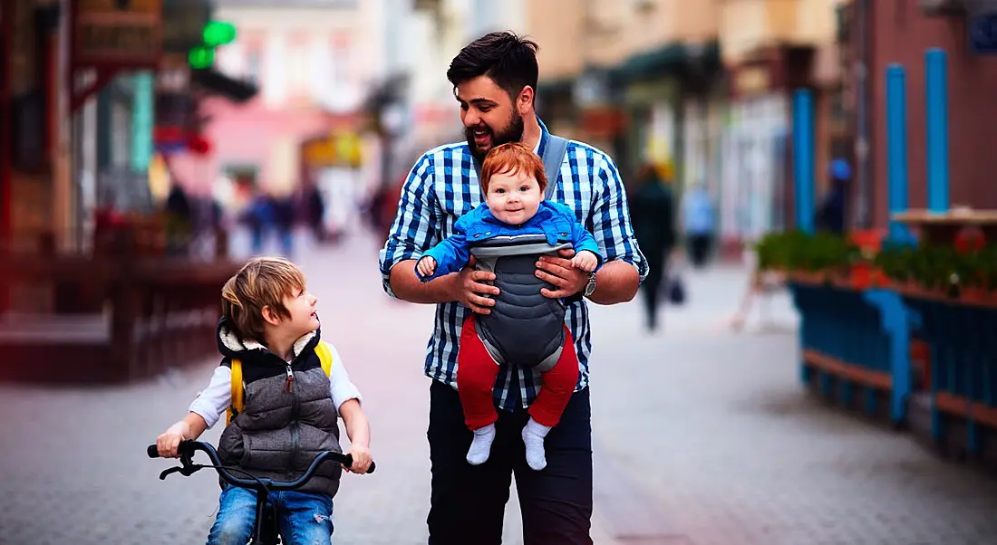 A happy father and two sons walking together outside.