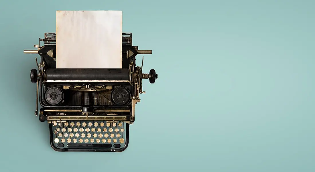 Vintage typewriter header with old paper on a teal background.