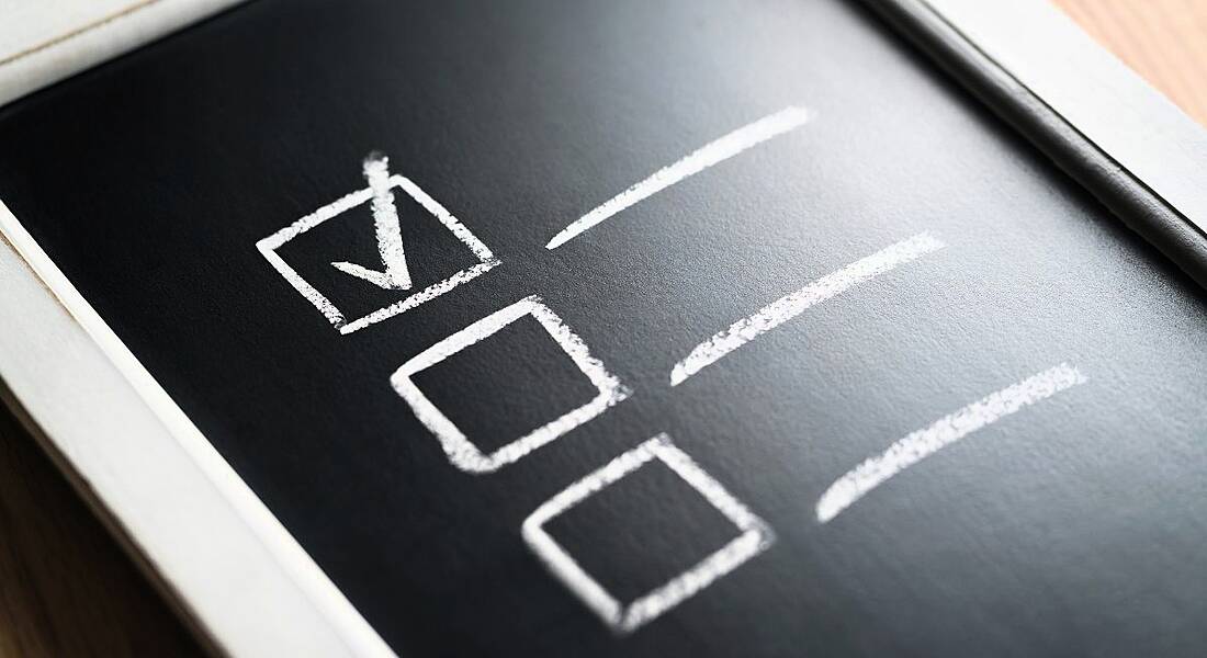 Checklist on a black chalkboard, with a box ticked in white chalk.