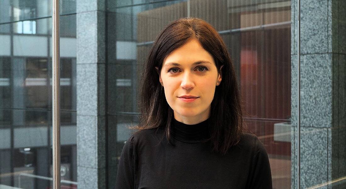 A professional woman is looking into the camera in Accenture's Dublin office.