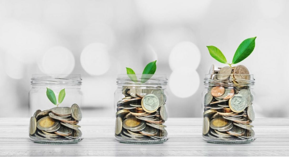 Three jars in a line are holding increasing amounts of money, each with growing leaves coming out of them symbolising monetary growth over time.