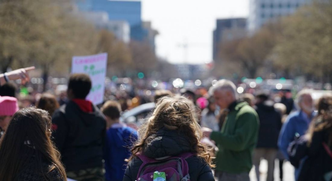 People protesting for justice outdoors in a city, with buildings in the background.