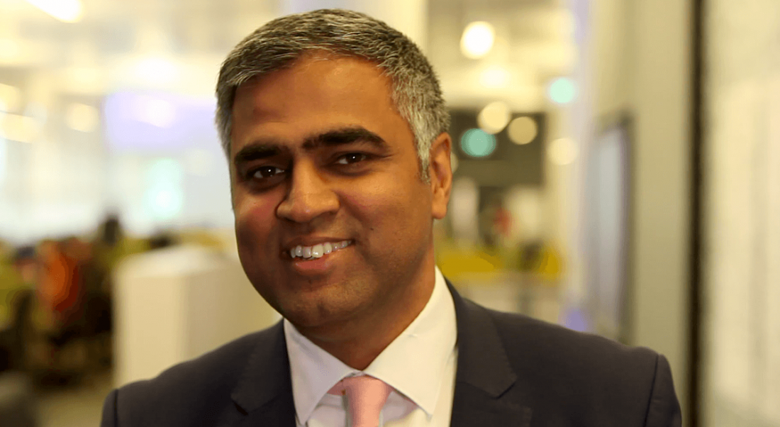 A professional man in a suit is smiling into the camera in the Dublin office of Citi.