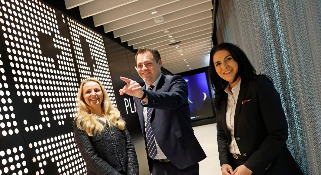 Two women from KPMG and an Irish minister standing in a hallway.