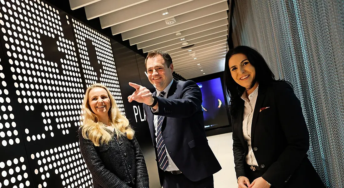 Two women from KPMG and an Irish minister standing in a hallway.