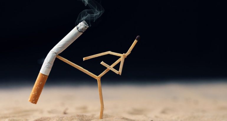 A matchstick constructed to look like it is practising karate kicks a cigarette in the air indicating the banning of smoking.