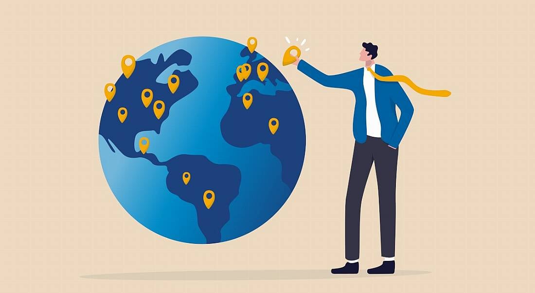 A business person pins a location on a globe, to represent the global expansion of their business.