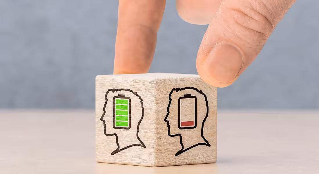 A dice with 2 figures, 1 with a low mental battery, 1 with a full battery, to represent the level of workplace stress