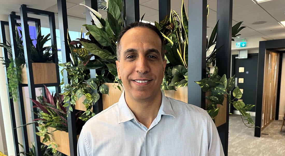 A headshot of Workhuman's Shmulik Barel smiling at the camera in a bright office.