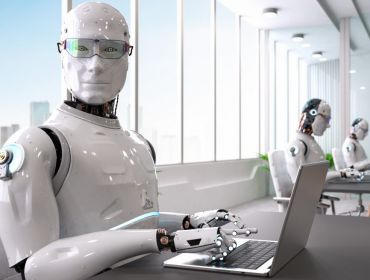 A robot, representing AI domination in the workforce, sits in an office with AI co-workers, working on a computer.