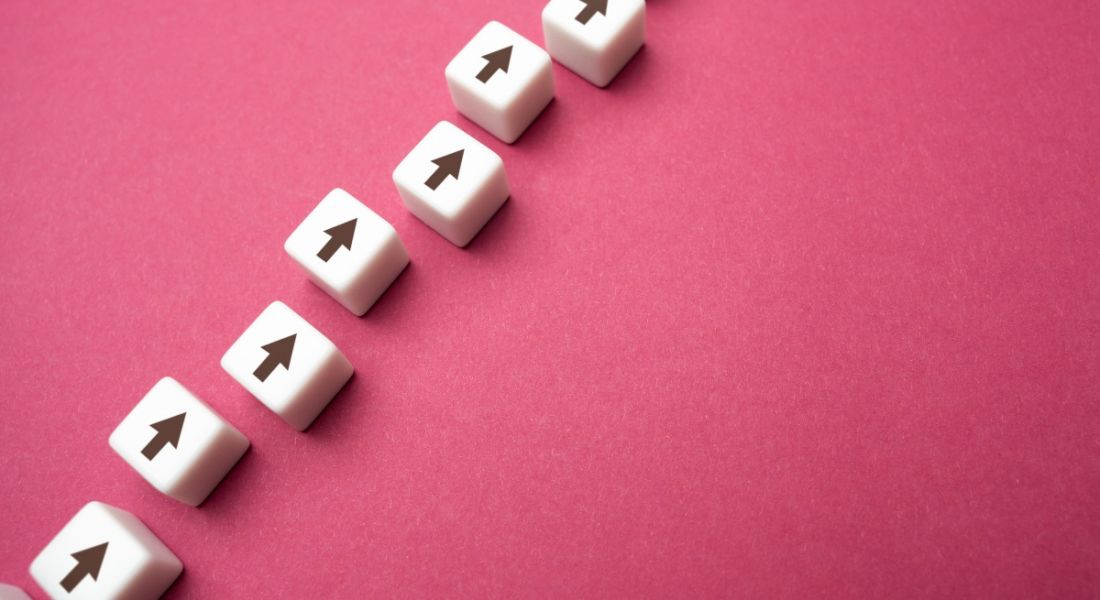 Arrows on tiles, against a pink background are pointing upwards, indicating skill progression.