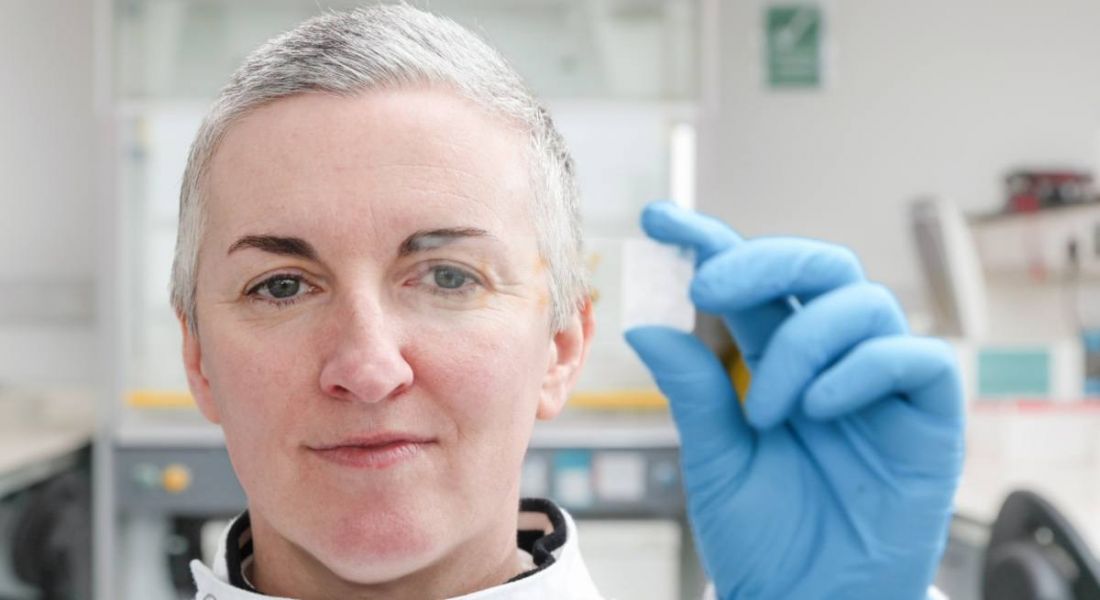 Prof Eilis Dowd of University of Galway holds up a slide in her gloved hand.