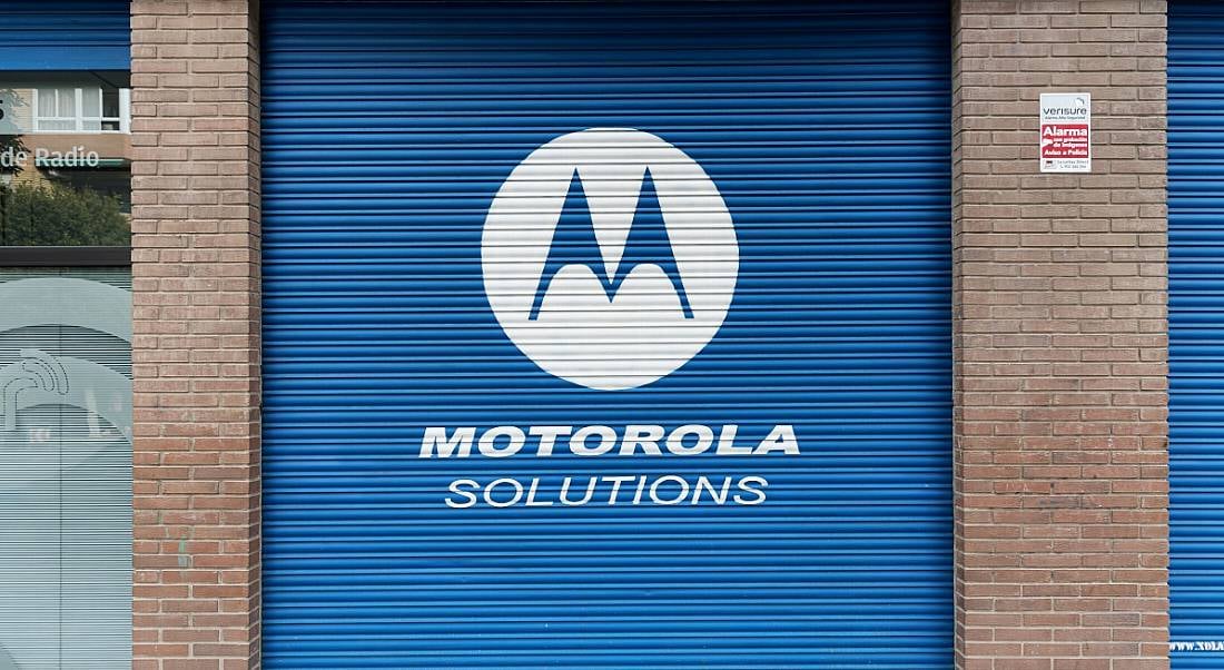 A blue garage door sits closed with the Motorola Solutions logo and name displayed across it in white.