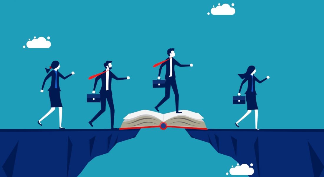 Four cartoon business people are using a book to cross a wide chasm, symbolising bridging the skills gap with education.