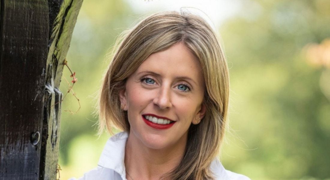 A headshot of Doctor Mary-Clare Race smiling with trees in the background.