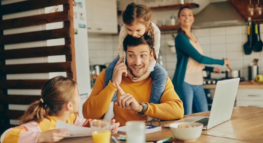 A man is pestered by kids and tries to work despite the difficulty, representing the need for parental and caregiver flexibility.