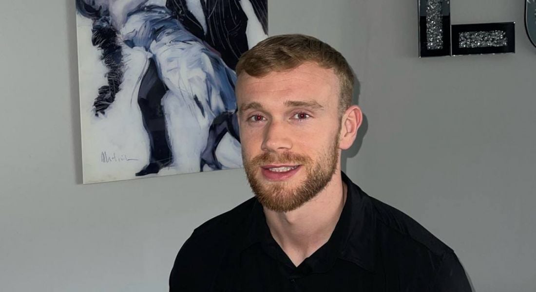 A young man wearing a black shirt smiling at the camera. He is Jack Kelly of Grant Thornton.