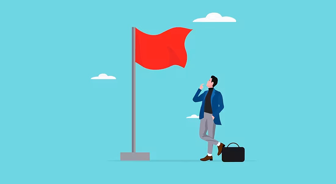A business man looks up at a red flag warning him.