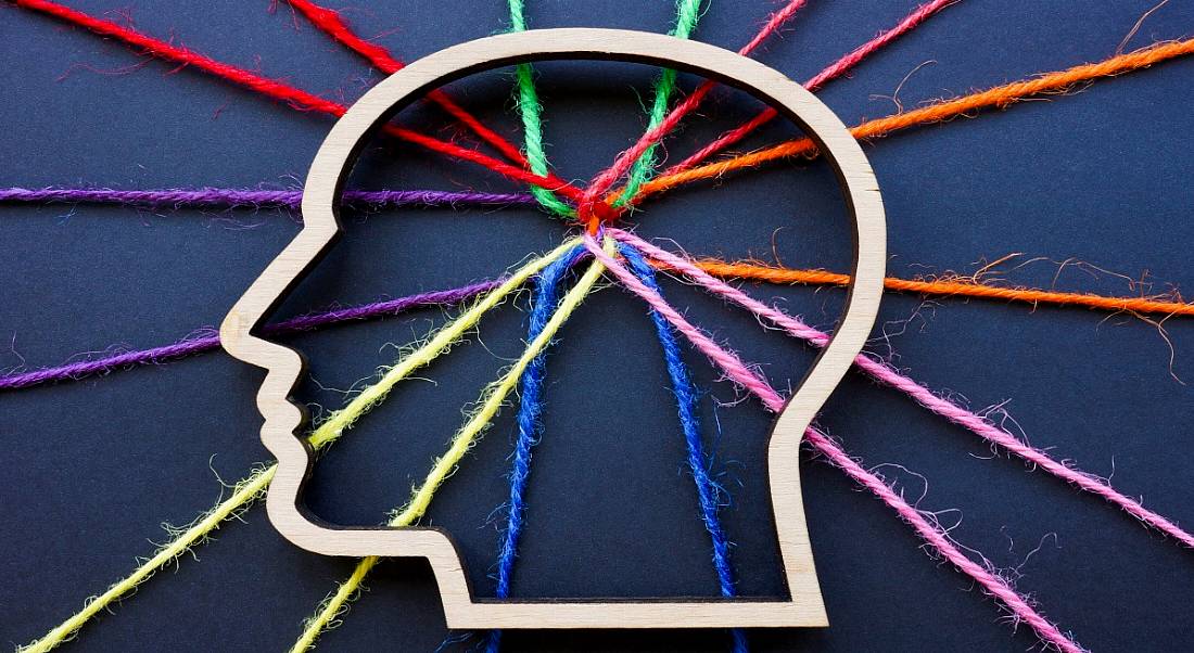 A drawing of a head with interconnected colourful strings, indicating cognitive diversity.