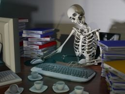 A worker looks at his screen as his diverse co-workers engage with him and each other from their remote-based offices.