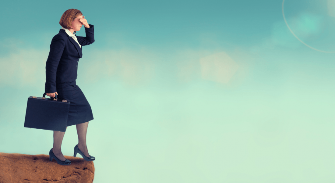 A business woman hovers on the edge of a cliff with her eyes closed, symbolising taking a blind leap into the unknown.