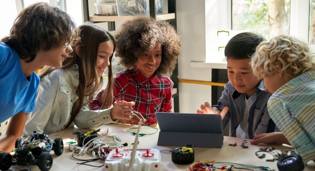 Diverse children collaborate on a STEM project.