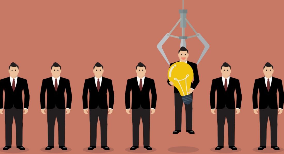 Cartoon showing a row of jobseekers in suits and one is being picked up by a robotic hand. He is holding a lightbulb.