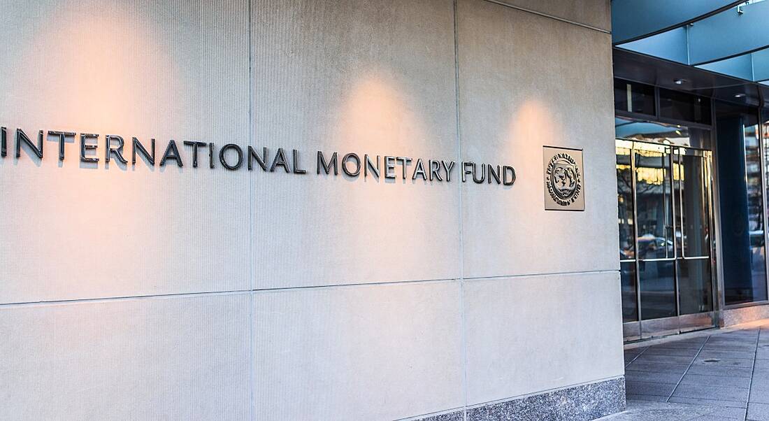 The entrance to a building with the IMF logo on the wall outside it.