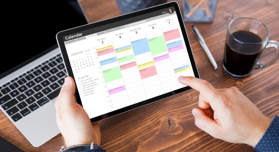 Worker using a calendar app on a tablet.