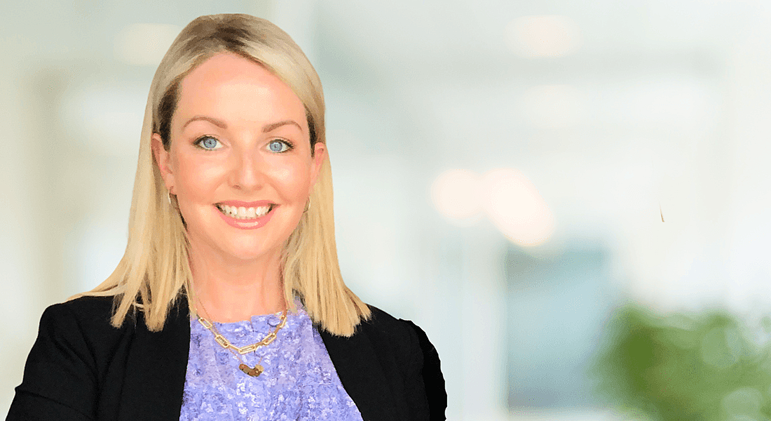 Clodagh Ryan close-up. She smiles at the camera wearing a lavendar top and black blazer, against a blurred light background.