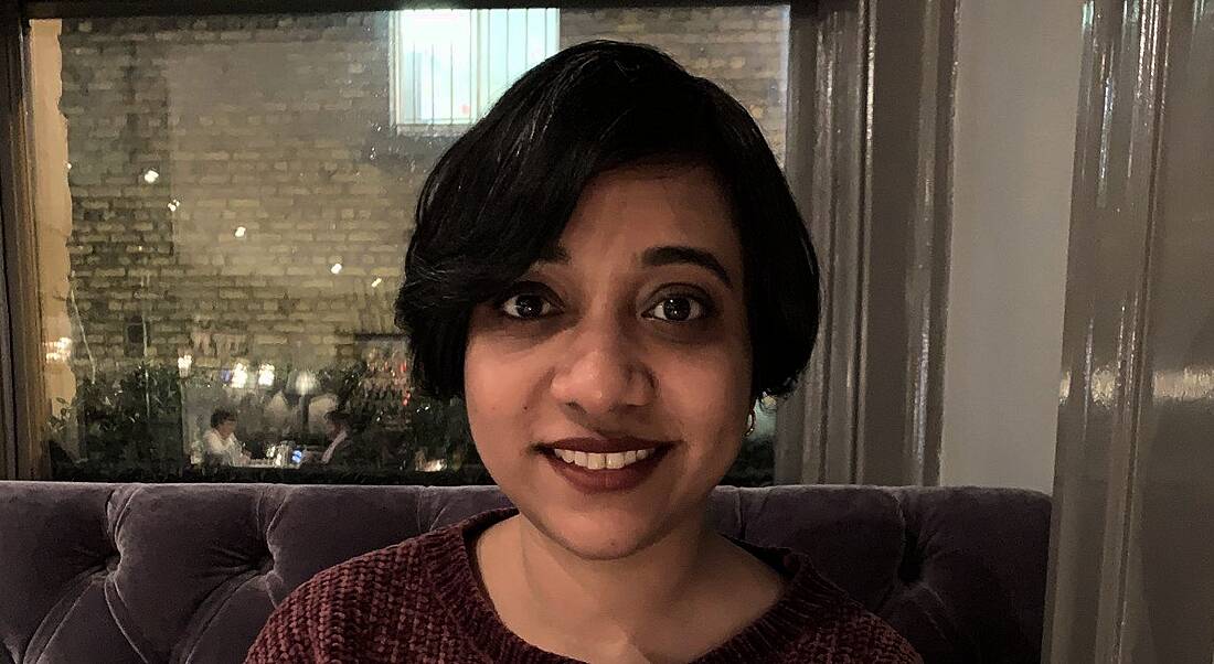 A woman smiles at the camera in a restaurant setting. She is Ankita Shrivastva, a data science manager at Accenture.