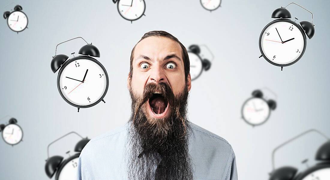 Agitated, screaming man with alarm clocks behind him floating around.