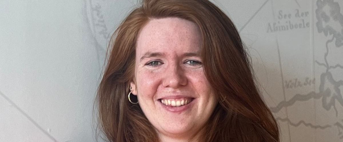 A close-up headshot of a young woman with red hair. She is Rachel Lawton, senior software engineer in Red Hat.