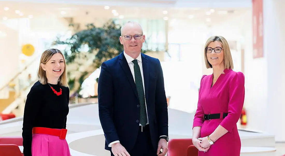 Two women from Vodafone Ireland and Irish Minister Simon Coveney standing together in a room.